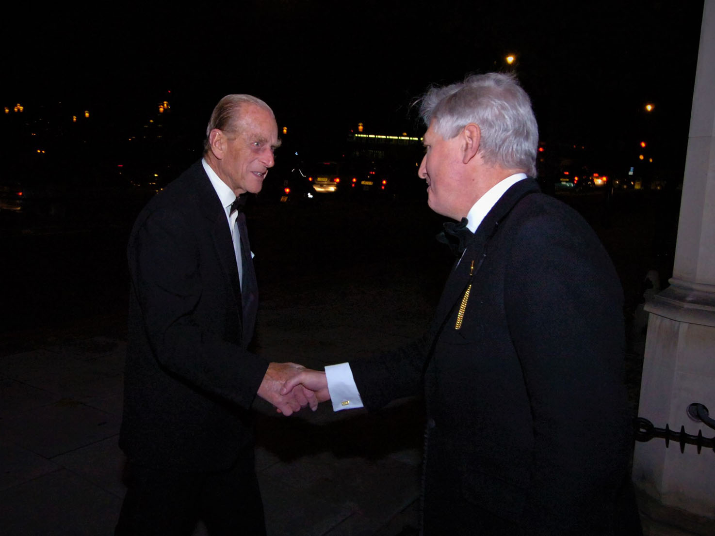 Duke of Edinburgh shaking hands with Dr. Moran outside of Crosby Moran Hall in the evening.