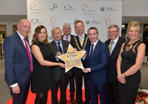 L - R: Peter Sheridan, Chief Executive Co-operation Ireland, Jnr Minister Megan Fearon MLA, Dr Christopher Moran, Chairman of Co-operation Ireland, Tom Dowling, Chairman of the Pride of Place Committee, Lord Mayor of Belfast Brian Kingston, Damien English TD, Minister of State for Housing and Urban Renewal, George Jones IPB Chairman and Suzanne Wylie, Chief Executive Belfast City Council